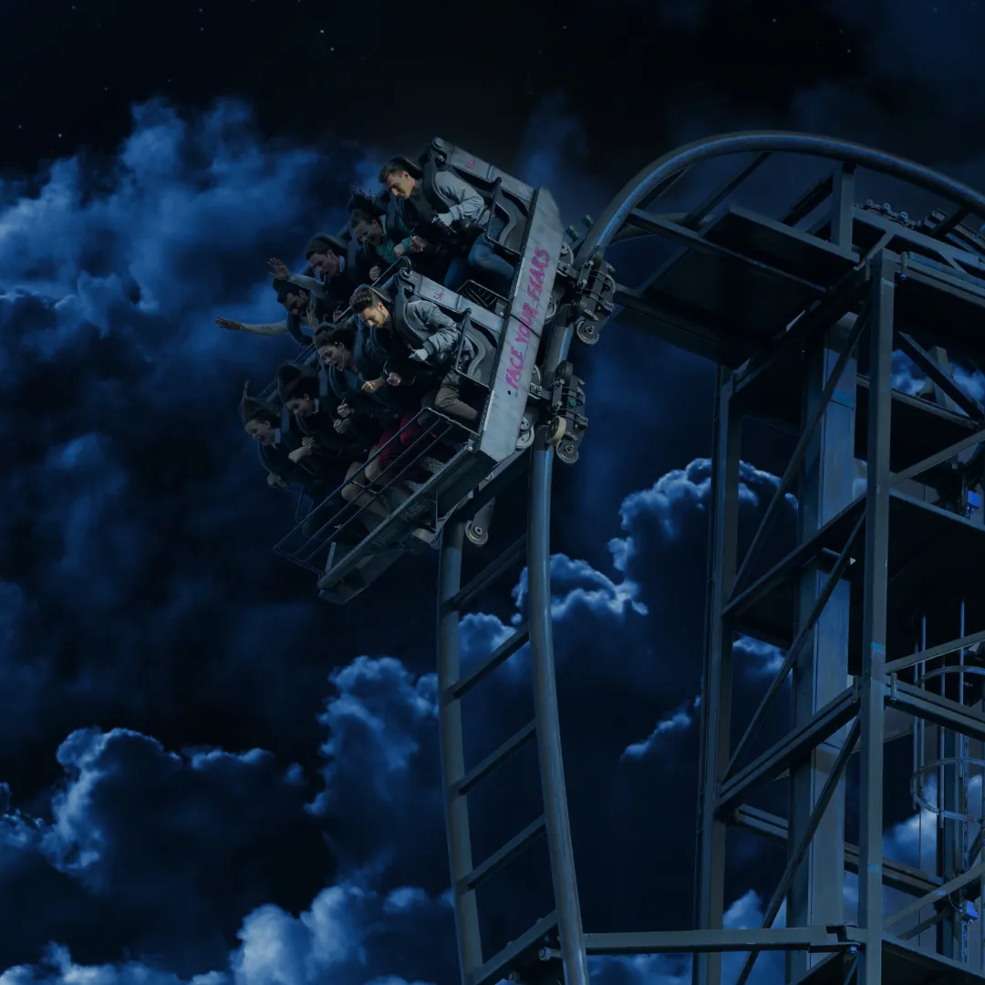 SAW – The Ride plunges down its steep drop in complete darkness, with the track barely visible against the night sky.