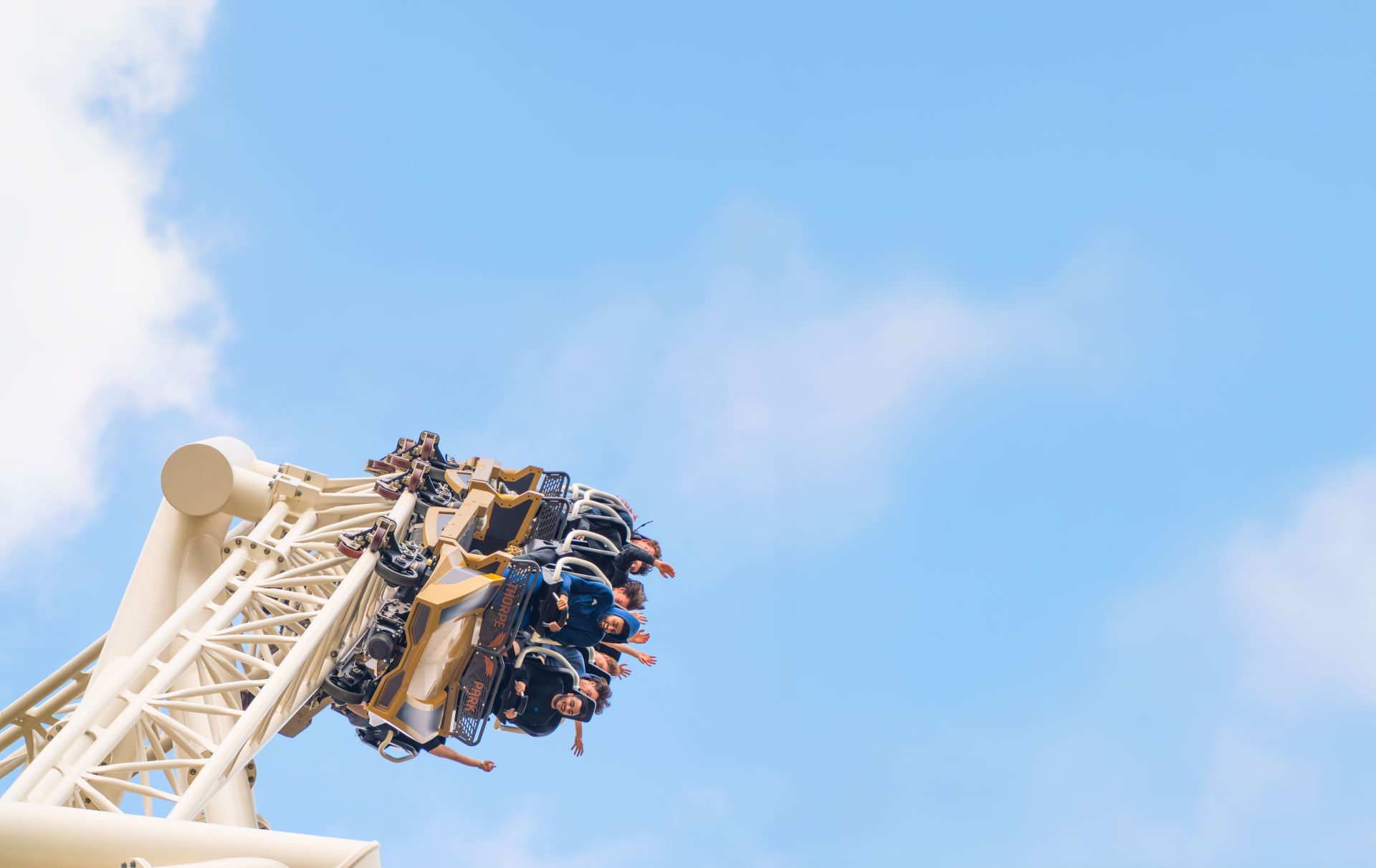 Guests on the ride Hyperia with a blue sky behind them 